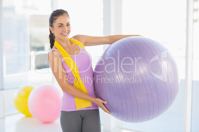 Portrait of happy woman holding exercise ball