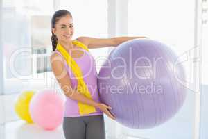 Portrait of happy woman holding exercise ball