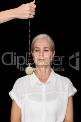 Cropped image of hypnotherapist holding pendulum before woman