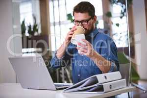 Businessman drinking office while using cellphone at creative of
