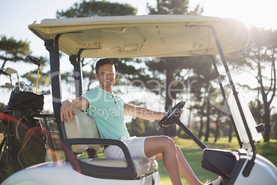 Portrait of smart man sitting in golf buggy