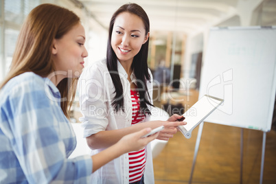 Female colleagues with digital tablet in creative office