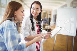 Female colleagues with digital tablet in creative office