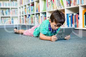 Boy using digital tablet in school library