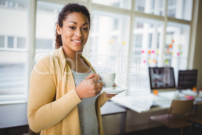 Portrait of businesswoman having coffee in creative office