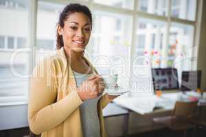 Portrait of businesswoman having coffee in creative office
