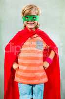 Boy dressed as superhero standing in classroom