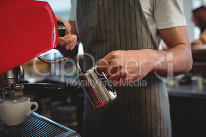 Midsection of barista using espresso maker at coffee house