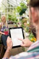 Cropped image of gardener using tablet at greenhouse