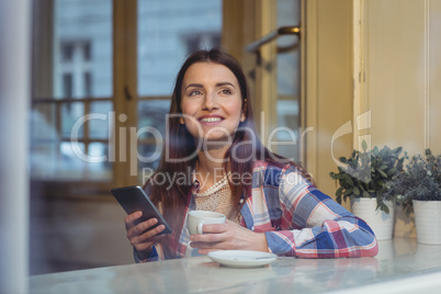 Happy beautiful woman with cellphone at cafe