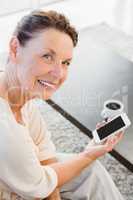 Portrait of happy mature woman holding smartphone