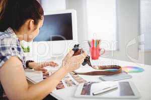 Woman holding camera in office