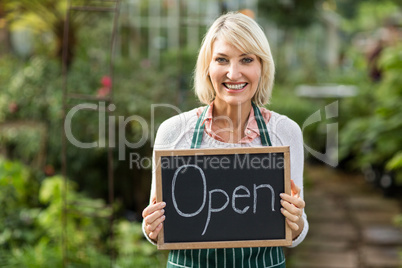Mature woman holding open sign placard