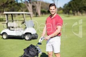 Portrait of smiling man holding golf club
