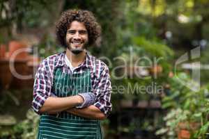 Confident male gardener standing at greenhouse