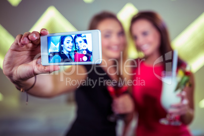 Smiling friends taking selfie in nightclub