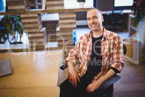 Businessman sitting by desk in creative office