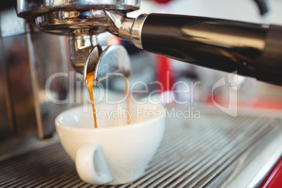 Close-up of espresso maker pouring coffee at cafe