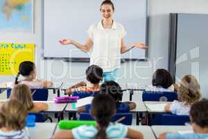 Teacher with arms outstretched in classroom