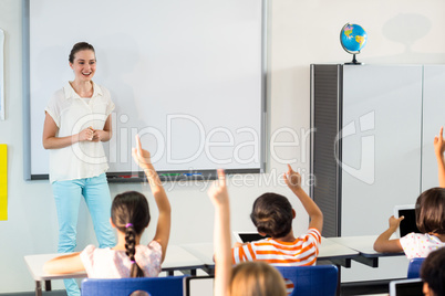 Teacher looking at students raising their hands
