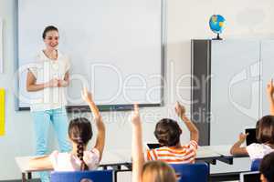 Teacher looking at students raising their hands
