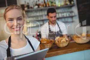 Portrait of confident waitress with digital tablet