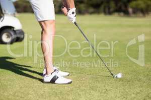 Low section of young man playing golf