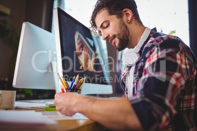 Creative businessman working at computer desk in office