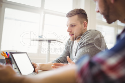 Young businessmen using digital tablet in office Young businessmen using digital tablet in office