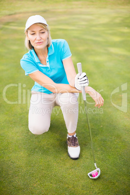 Golfer woman crouching on golf course