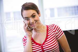 Portrait of happy executive listening to cellphone at office