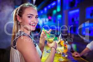 Portrait of smiling woman holding cocktail glass