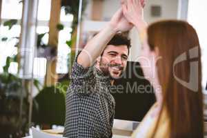 Businessman giving high-five to female coworker