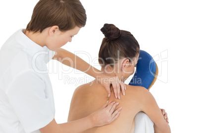 Masseuse giving back massage to naked woman