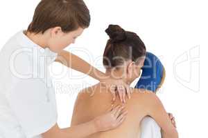 Masseuse giving back massage to naked woman