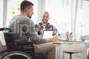 Handicap businessman sitting with colleague in office