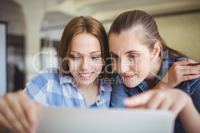 Happy young businesswomen working on laptop in office