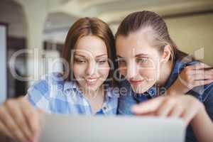 Happy young businesswomen working on laptop in office