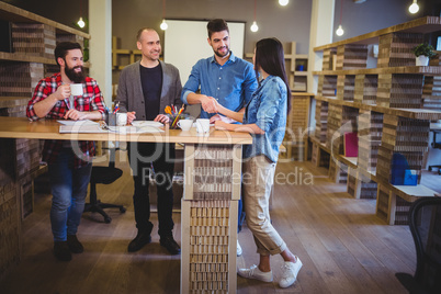 Colleagues shaking hands at table in office