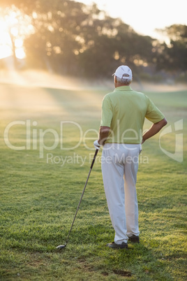 Rear view of mature man holding golf club