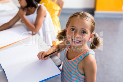 Portrait of happy girl writing on book