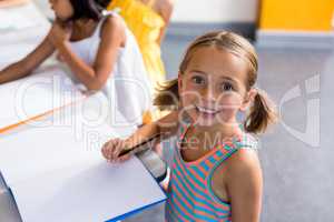 Portrait of happy girl writing on book