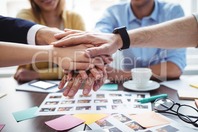 Colleagues hand stacking in meeting room