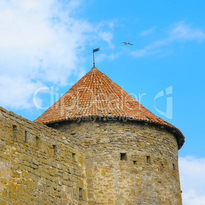 fortress tower with tiled roof on blue sky background