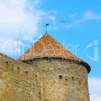 fortress tower with tiled roof on blue sky background