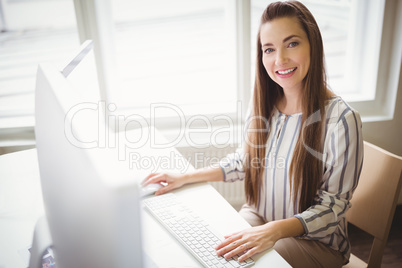 Smiling businesswoman working on computer in office