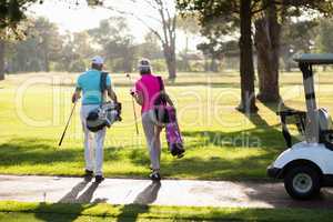 Rear view of mature golfer couple