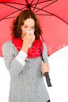 Mature woman suffering from cold while holding umbrella