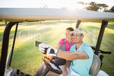 Smiling golfer couple taking selfie