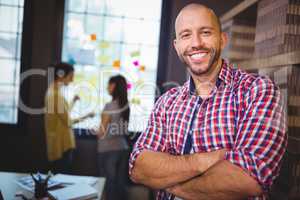 Confident businessman with colleagues in background